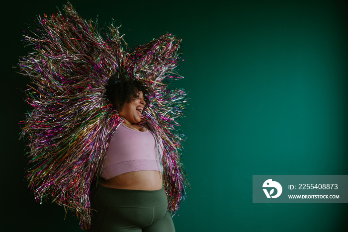 portrait of a plus size woman with a rainbow tinsel jacket