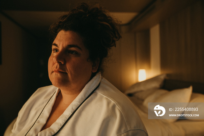 moody photo of woman in a hotel room wearing robe