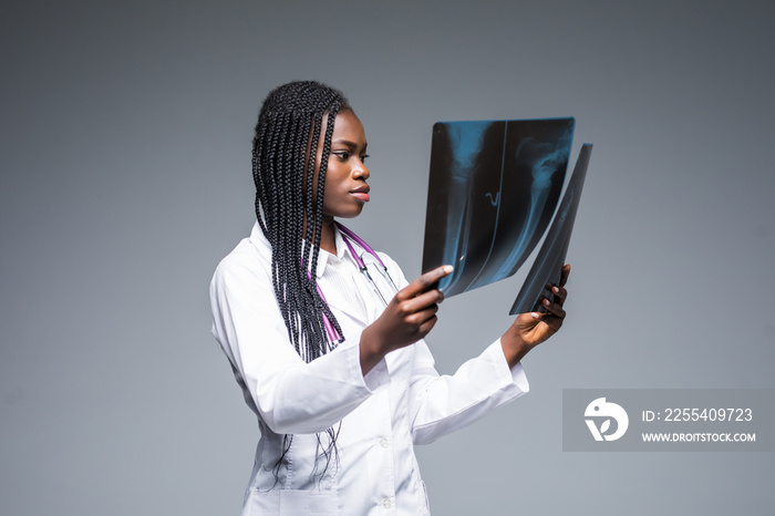 Young african Female doctor looking at an x-ray isolated on gray background