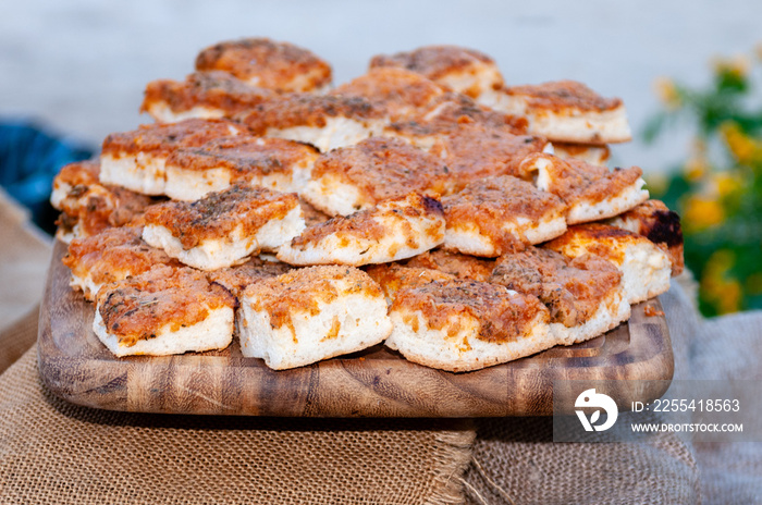 Sfincione, tipica focaccia siciliana dell’area del palermitano , condita con pomodoro ed estratto di pomodoro, cipolla soffritta acciughe,  o sarde salate, caciocavallo a tocchettini ed origano.