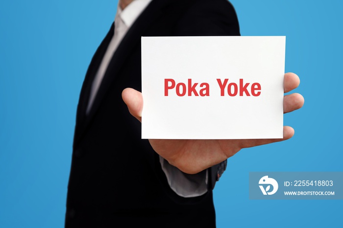 Poka Yoke. Business man in a suit holds card at camera. The term Poka Yoke is in the sign. Symbol for business, finance, statistics, analysis, economy