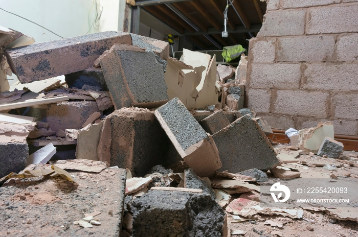 Demolished breeze block interior wall inside a factory. Part of a reconstruction project.  Building site rubble