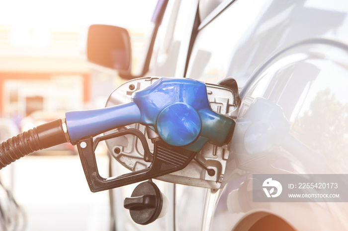 Fuel nozzle to refill fuel in car at gas station. Power concept.