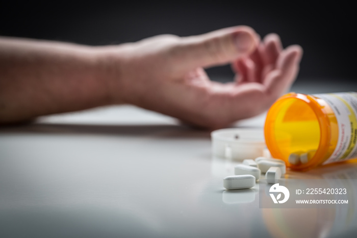 Man Passed Out on Floor Behind Scattered Drugs and Medicine Bottle.