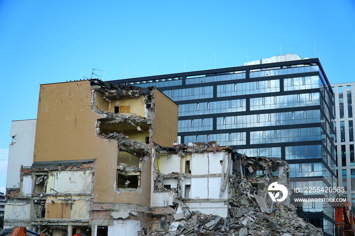 Office buildings demolition and crashing by machinery for new construction in Cracow, Krakow, Poland.