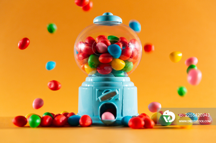 candy machine with jelly beans, multicoloured jelly beans, orange background