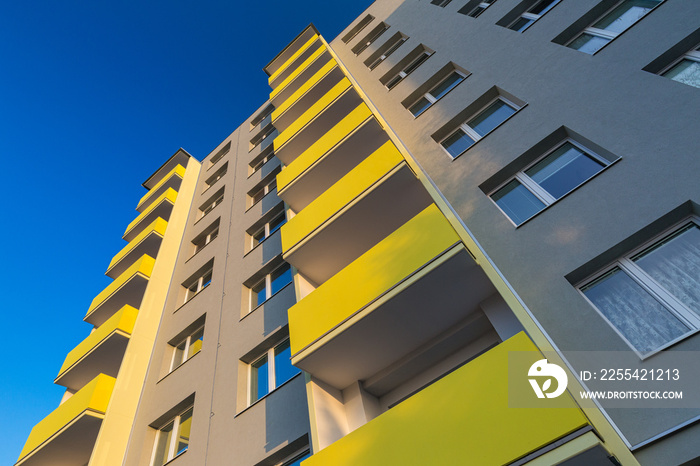 Facade of a renovated apartment block of flats with balconies..