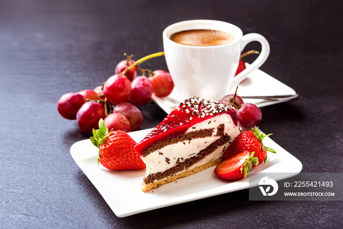 Breakfast. Dessert and coffee. A cup of hot coffee with crema, cake and fruit. Grapes, strawberries and fruit cake. Still life on a dark background