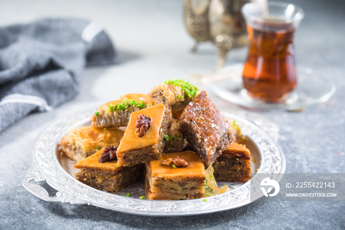 Traditional Turkish Desserts Baklava with  Tea. Crispy mix baklava on silver  plate.