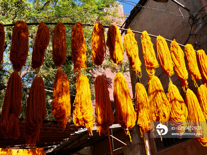 Bundles of orange wool hanging to dry at dyers souk, Marrakech, Morocco.