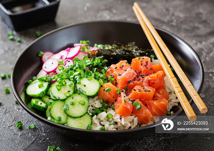 Hawaiian salmon fish poke bowl with rice, radish,cucumber, tomato, sesame seeds and seaweeds. Buddha bowl. Diet food