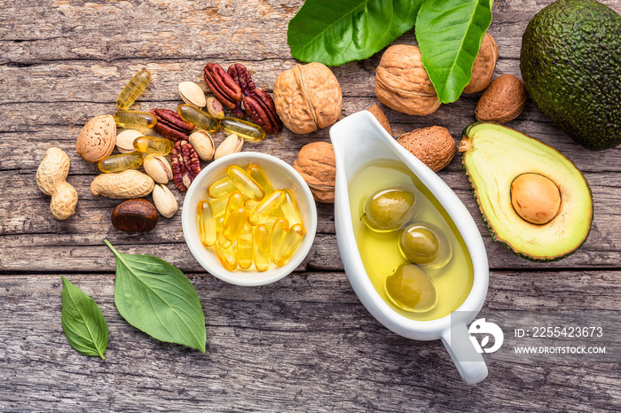 Selection food sources of omega 3 and unsaturated fats. Superfood high vitamin e and dietary fiber for healthy food. Almond,pecan,hazelnuts,walnuts,olive oil,fish oil and salmon on wooden background.