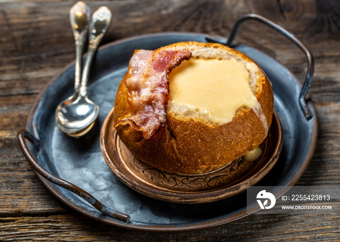 Cheese soup with bacon and herbs served in bread on wooden background, Restaurant menu, dieting, cookbook recipe