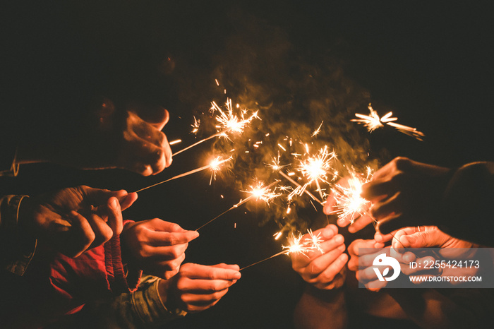 Closeup image of hands holding sparklers for celebrate in the night time