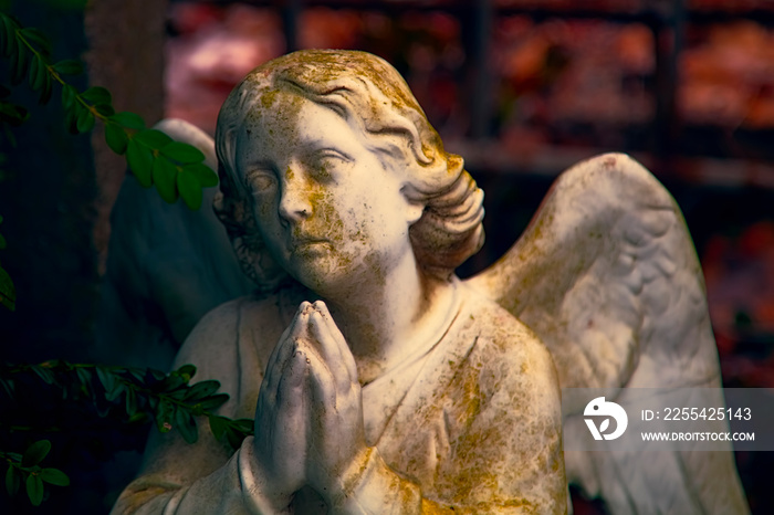 An ancient stone statue of praying angel.