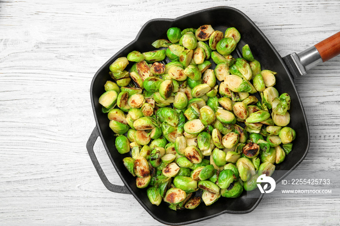 Grill pan with roasted brussel sprouts on wooden background