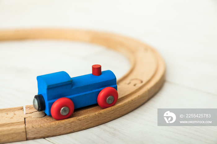 Child’d wooden train on the white floor