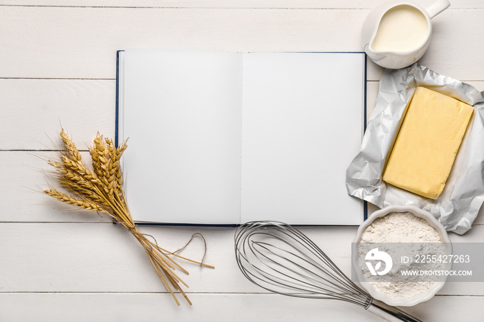 Cook book with products on white wooden background