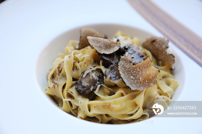 pasta with black truffles on wood background , Italian food