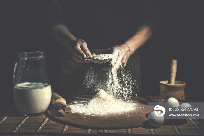 Man preparing bread dough on wooden table in a bakery close up. Preparation of Easter bread.