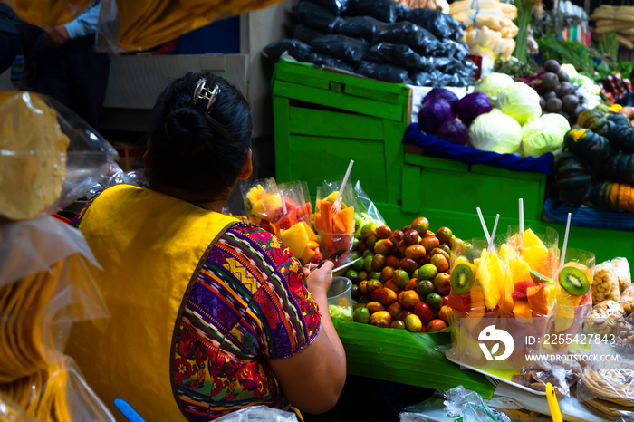 Una mujer vende frutas en el mercado del pueblo Zunil Guatemala.