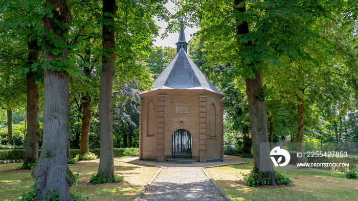 Panorama view of old church tower (Van Gogh kerkje) encompass big trees and green leaves in summer, Walking in the footsteps of Vincent van Gogh paintings, Nuenen, Netherlands.