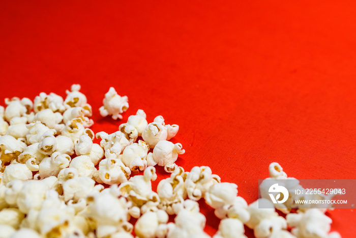 Tasty salted popcorn isolated on red background. Popcorn border isolated on red, clipping path included. Cinema, movies and entertainment concept.