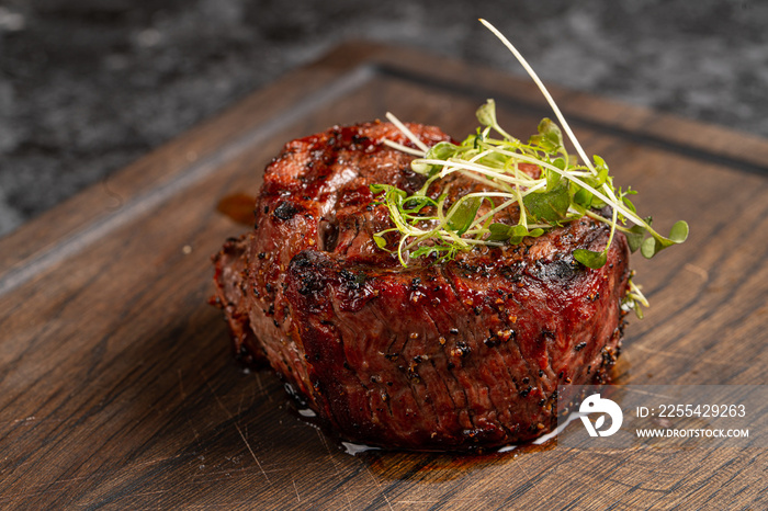 Fried beef fillet medallion steak close up on a wooden cutting board