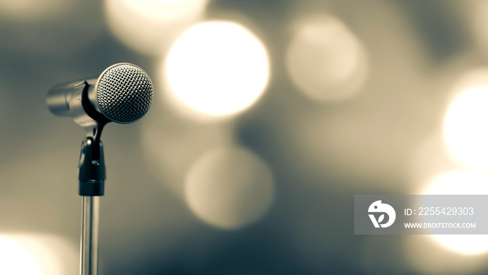 Microphone Public speaking backgrounds, Close-up the microphone on stand for speaker speech presentation stage performance with blur and bokeh light background.