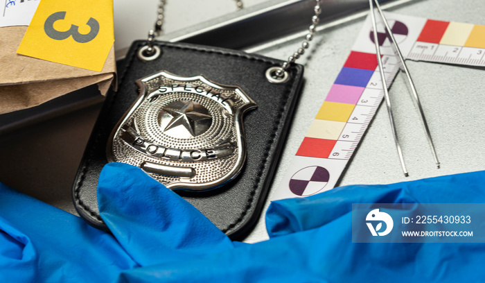 Police badge with gloves and ballistic measuring ruler