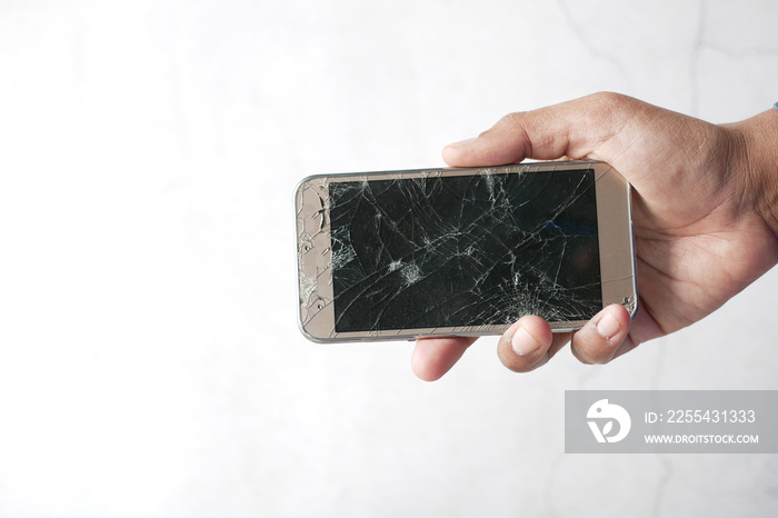 Close up of man hand holding broken smart phone.