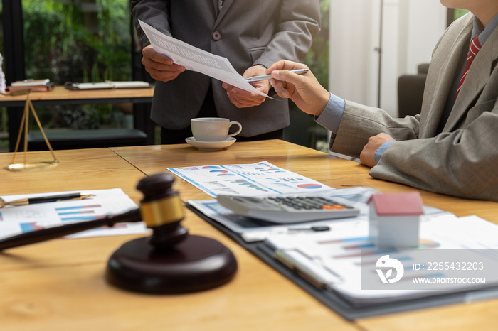 Concepts of law, Lawyer and businessman shaking hands in office after discussing contract and business papers.