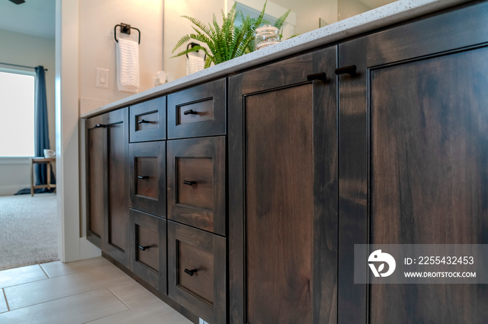 Brown wooden vanity bathroom cabinets with white countertop and black handles