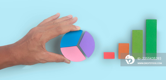 Business connecting piece of multi colored pie chart in  hand