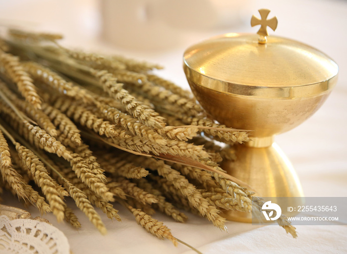 ears of wheat with golden chalice on an altar