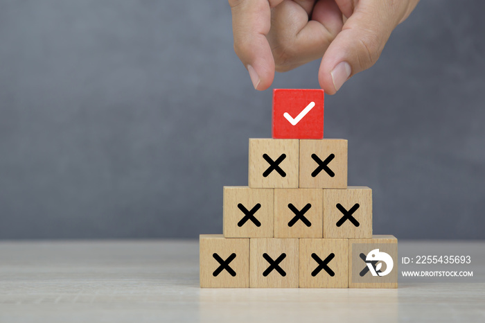 Hand choose wooden block stack with check mark and cross symbol for customer survey service and feedback.