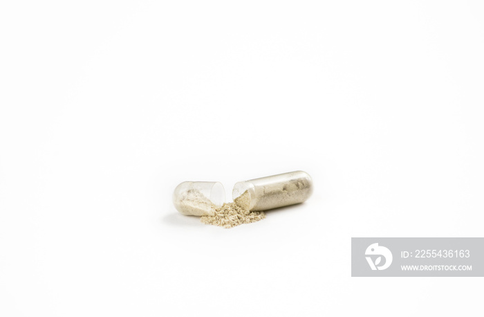 Close up of the open gel medical capsule with powder inside pouring out isolated on white background space for text.