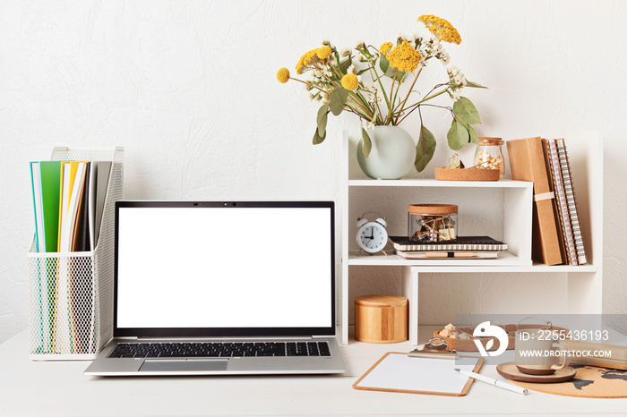 Empty laptop screen, desktop organizer with desk shelves and office supplies. Back to school, home office, begining of studies concept. Mockup, template