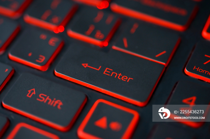 Red backlit computer keyboard macro shot of enter key