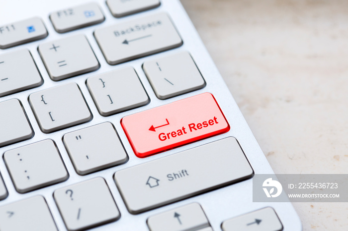 Silver grey keyboard close up with world global great reset enter- button on marble background.