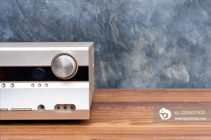 Half front side AV receiver with volume and AUX Plugin on wood table