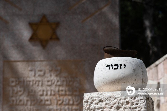 A stone marker holding an old soldier’s helmet is engraved with the Hebrew word for  remember  on the grounds of the Mt. Herzl military cemetery in Jerusalem.