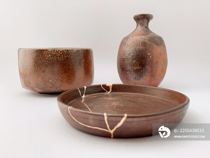 Brown Kintsugi pottery, bizen ware with gold scars repair