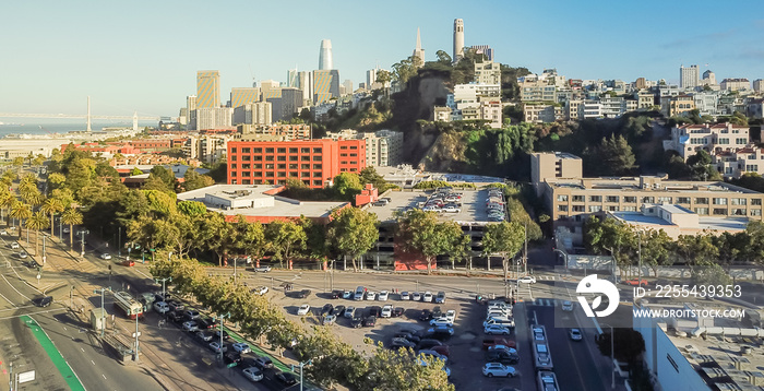 Panorama aerial view Embarcadero boulevard and Telegraph Hill neighborhood from Pier 39 at sunset. Coit Tower is located at the top of the hill, San Francisco, California, USA