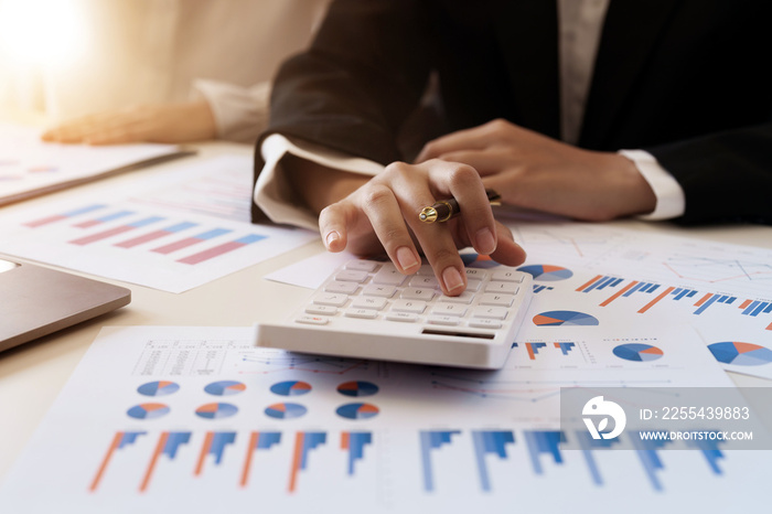 Businesswoman or accoutant calculates financials with graph report on the table on the cost of office.