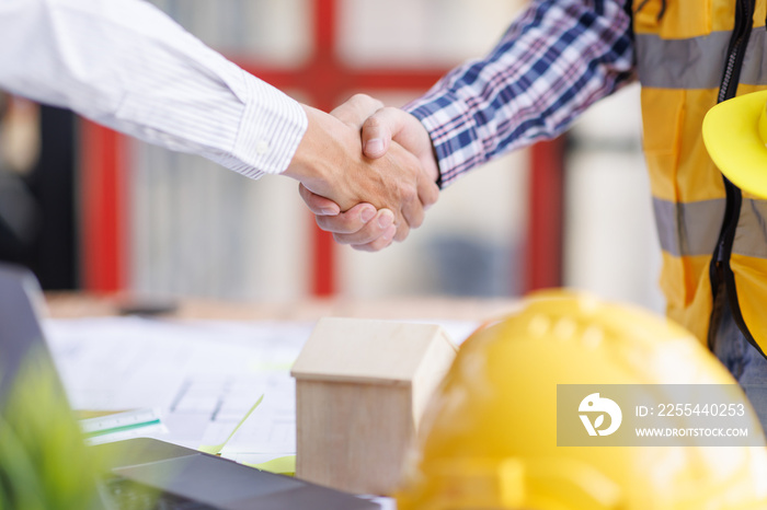 Architect contractor shaking hands with client after seal a deal to renovate building, engineer handshake partnership and contractor concept