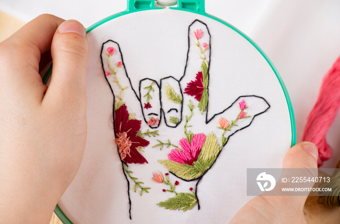 girl embroiders hand embroidery in colors, cool gesture