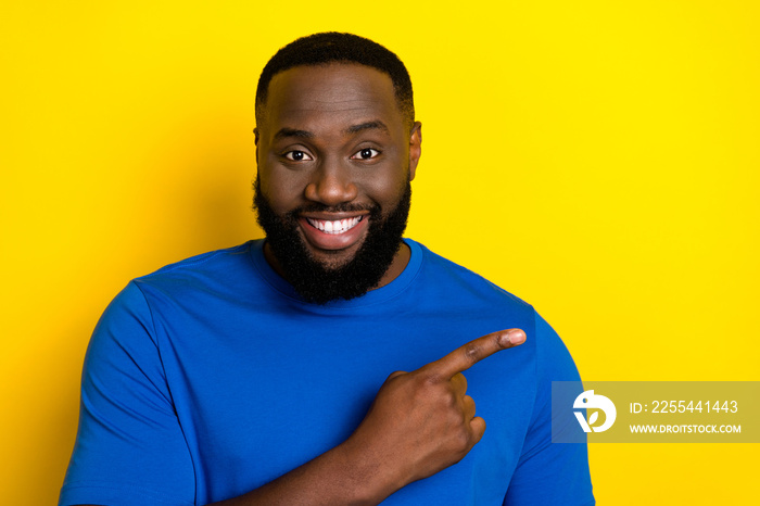 Portrait of attractive cheerful guy demonstrating copy space look solution isolated over bright yellow color background