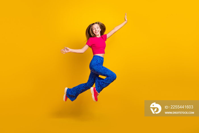 Photo of positive cute lady wear bright comfort clothes celebrate success win triumph fly empty space isolated on yellow color background