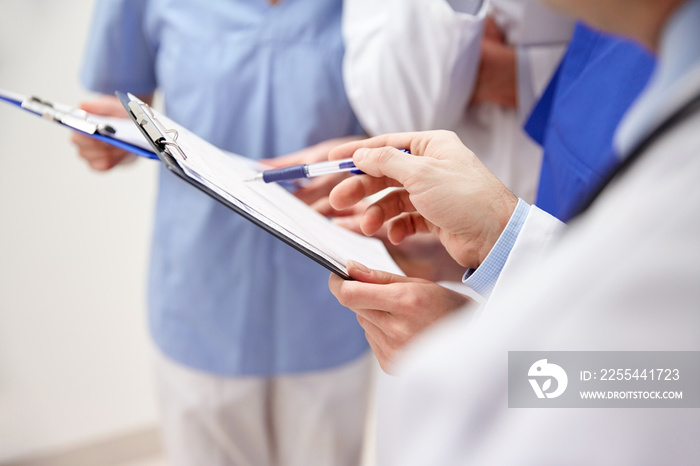 close up of doctors with clipboard at hospital